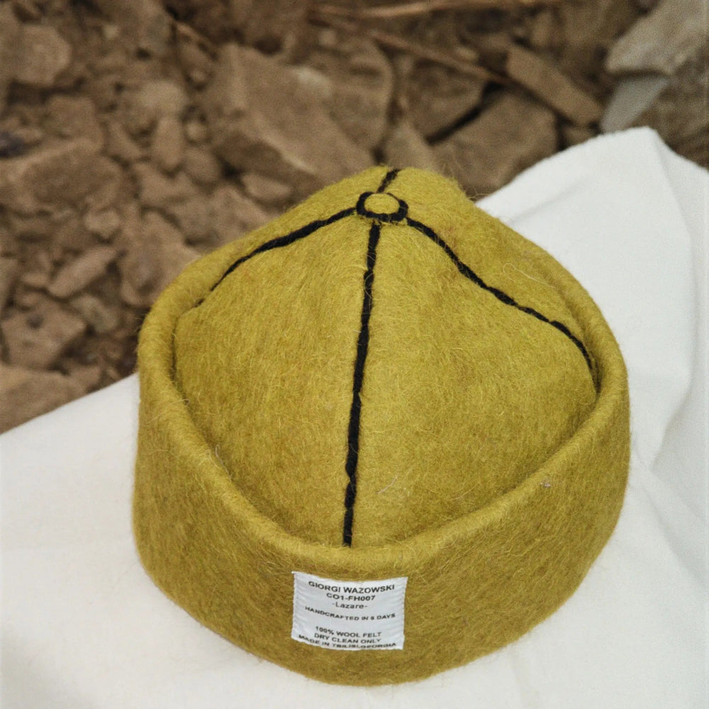 Detailed view of Mustard hatâ€™s stitching and label by Giorgi Wazowski